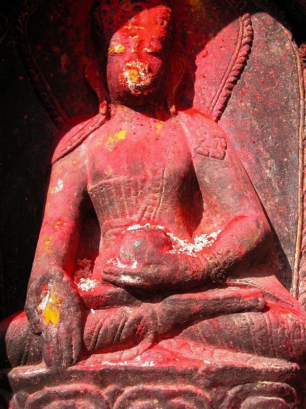 Kathmandu Boudhanath 07-2 Ratnasambhava Statue Closeup A statue of Ratnasambhava glows in the afternoon sun at the Boudhanath Stupa near Kathmandu. Ratnasambhava is the Dhyani Buddha of the south, is yellow, with his right hand in the mudra of generosity while his left hand holds the ratna or wish-fulfilling jewel.